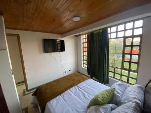 um quarto com uma cama e uma grande janela em Santamaria Lago Home em Bogotá