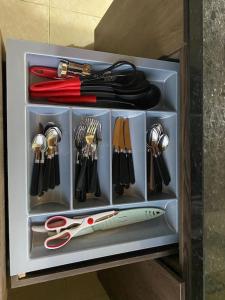 a drawer filled with utensils and a pair of scissors at Santamaria Lago Home in Bogotá