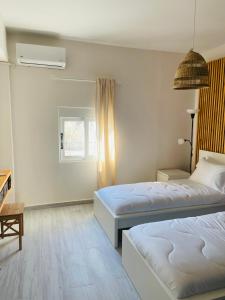 a bedroom with two beds and a window at Beach Side Apartment in Kardamaina