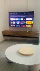 a white coffee table in front of a flat screen tv at Beach Side Apartment in Kardamaina