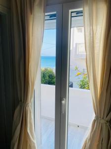 a sliding glass door with a view of the ocean at Beach Side Apartment in Kardamaina +8 photos