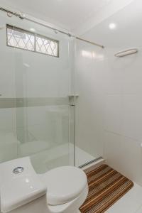 a bathroom with a toilet and a glass shower at Casa Hotel Miriam in Montería