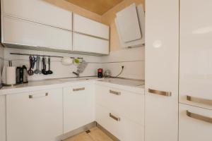 a white kitchen with white cabinets and a sink at Apartment KIM in Umag