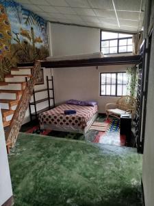 1 dormitorio con 1 cama y una escalera en una habitación en Casita Tz'ikin, en San Pedro La Laguna
