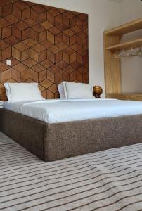 Cama grande en habitación con pared en Appartements meuble SEED, en Yaoundé