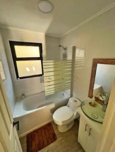 uma casa de banho com um WC, uma banheira e um lavatório. em Casa cercana a playas y bosque em Valparaíso