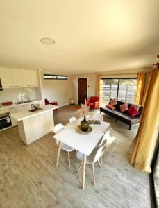 uma sala de estar com uma mesa branca e cadeiras em Casa cercana a playas y bosque em Valparaíso