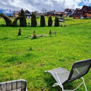 uma cadeira sentada na relva num campo em ECO Domek z dużym ogrodem i widokiem em Murzasichle