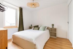 ein weißes Schlafzimmer mit einem Bett und einem Fenster in der Unterkunft Le Aristide - Centre Ville - Calme - Terrasse in Saint-Nazaire