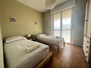 2 Einzelbetten in einem Zimmer mit Fenster in der Unterkunft Comfort living apartment in Orbassano