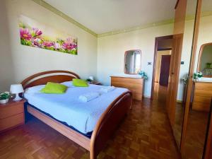 een slaapkamer met een bed met blauwe lakens en groene kussens bij Comfort living apartment in Orbassano
