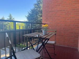 een tafel en stoelen op een balkon met een bakstenen muur bij Comfort living apartment in Orbassano