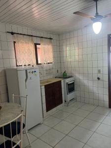 a kitchen with a refrigerator and a stove at Residencial Marémansa pousada apto 01 in Governador Celso Ramos