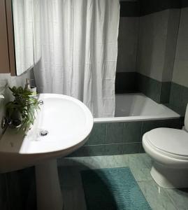 a bathroom with a sink and a toilet and a tub at Varosi Apartment in Komotini