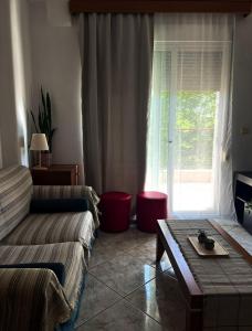 a living room with a couch and a table and a window at Varosi Apartment in Komotini