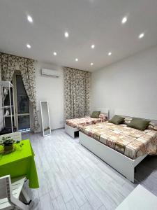 ナポリにあるOliver's Houseのベッドルーム1室(ベッド2台、緑のテーブル付)
