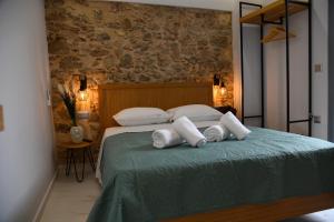 una camera da letto con un letto con tre cuscini sopra di Authentic Plaka Home ad Atene