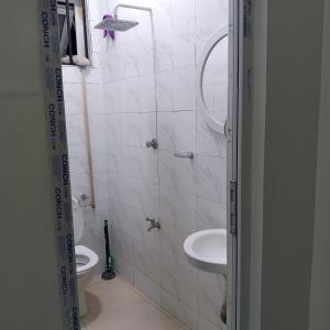 een badkamer met 2 wastafels en een spiegel bij Bamburi One Bedroom Apartment in Mombasa