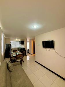 a living room with a couch and a tv on a wall at Apartamento totalmente equipado a 5 minutos del Parque del Café - Montenegro in Montenegro +35 photos