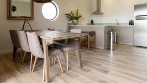 cocina y comedor con mesa de madera y sillas en The Beach House, en Willemstad