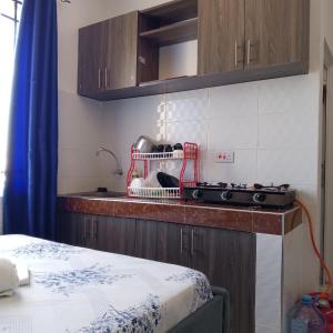 a kitchen with a counter with a sink and a stove at Bamburi One Bedroom Apartment in Mombasa