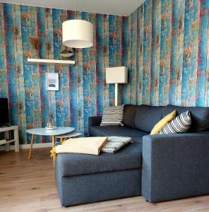a blue couch in a living room with a wallpaper at Ferienwohnung STRANDGUT in Behrensdorf