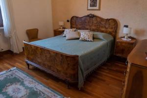 - une chambre avec un grand lit en bois et des oreillers dans l'établissement Agriturismo Pino Argentato, à Bussolengo