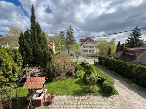 a garden with two cats sitting on a bench at Károly II. Vendégház in Hévíz