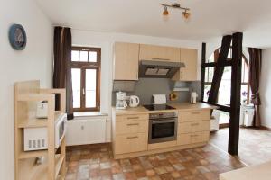 uma cozinha com armários de madeira e um forno com placa de fogão em Ferienwohnung Auszeit em Bad Berka