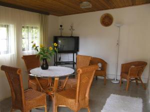 een eetkamer met een tafel en stoelen en een tv bij Muskátlis Ház in Balatonlelle