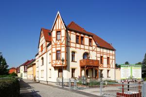 ein großes orangefarbenes und weißes Gebäude auf einer Straße in der Unterkunft Ferienwohnung Auszeit in Bad Berka