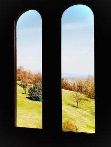 duas janelas com vista para um campo verde em Swanlake Villa em Meina