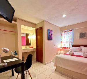 a bedroom with a bed and a desk and a television at Hotel Barranquilla in Campeche