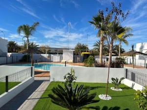 een binnenplaats met een zwembad en palmbomen bij Villa Lagarto - Denia El Verger in Denia