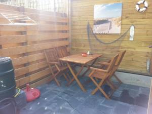 デン・ブルグにあるHomestay Texelの木製テーブルと椅子付きのパティオ