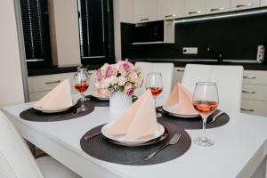 una mesa de comedor con copas de vino y servilletas en Rose Valley apartment en Kazanlŭk