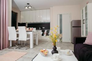 a living room and kitchen with a table and chairs at Rose Valley apartment in Kazanlŭk