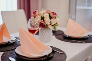 una mesa con un jarrón de flores y una copa de vino en Rose Valley apartment en Kazanlŭk