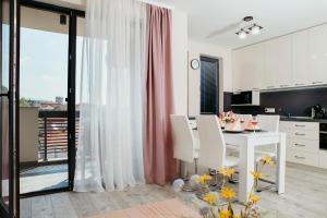 a kitchen and dining room with a white table and chairs at Rose Valley apartment in Kazanlŭk