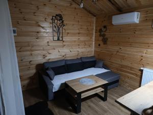 a living room with a couch and a table at Domek MODERN BARN- 4 tylko 800m od Suntago Ranczo Gold Mania in Krzyżówka