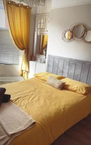 a bedroom with a large bed with yellow sheets at The Nook House in Liverpool