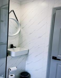 a white bathroom with a sink and a mirror at The Nook House in Liverpool