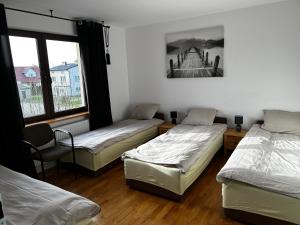 Skaryszew的住宿－Pokoje pokój u Bani，带三张床和椅子的房间