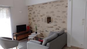 sala de estar con sofá y TV en Gîtes " la pagerie" en La Gaubretière