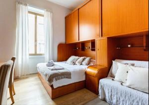 a bedroom with two beds and wooden cabinets at Chiarilù near the center Politecnico Fair and City Life in Milan