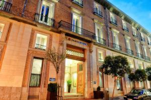 a large brick building with a wooden door on a street at NH Collection Madrid Palacio de Tepa in Madrid