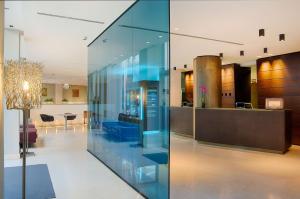 a glass wall in a lobby with a dining room at NH Bergamo in Bergamo