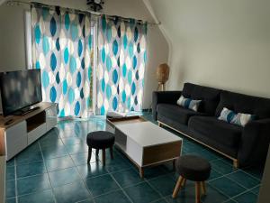 a living room with a couch and a table at L'olivier du Cabellou, à 900 m des plages in Concarneau