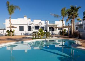 een zwembad voor een huis met palmbomen bij Villa Lagarto - Denia El Verger in Denia