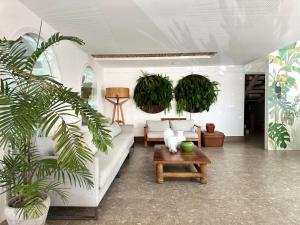 a living room with a white couch and plants at Passagem Concept Hotel e Spa in Cabo Frio